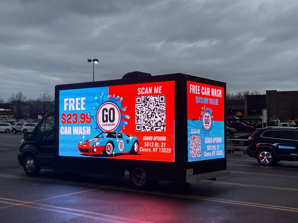 PixelMile LED billboard truck running a bright full-color digital ad outside a retail center